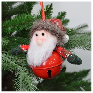 Detail of plush Santa Claus metal bell hanging ornament on a green Christmas tree branch