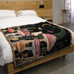 Close-up of woven mushroom forest tapestry featuring fringe details on white bedding