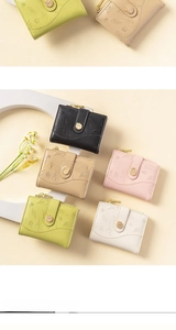 Detail of colorful short wallets with embossed leaf patterns and gold metal clasps