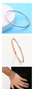 Detail of slim stainless steel bangles with sparkling crystals and diamond buckle closure