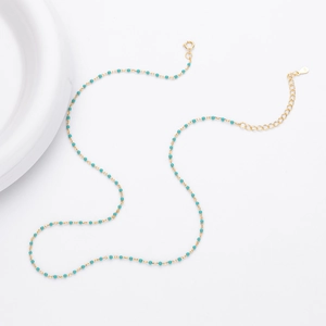 Close-up of gold chain necklace with turquoise beads and S925 hallmark on the clasp