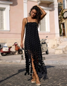 Detailed view of black midi dress with hollow-out polka dots and tassel hem for summer