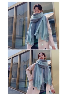 Detailed view of thick knit scarf featuring blue and grey color block with RG patch