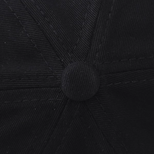 Detail view of the top button and 6-panel stitching on a black cotton baseball cap