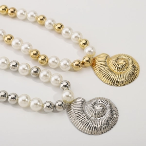 Detail of beaded pearl necklace with large gold and silver hollow conch shell pendants
