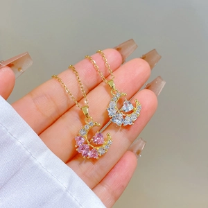 Detailed close-up of crescent moon necklaces in gold finish with pink and clear zircons