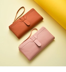 Detailed view of fashionable long women wallets with wrist straps in elegant brown and pink.