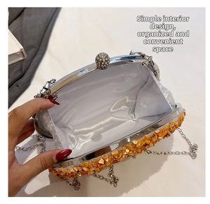 Detailed interior of pumpkin evening bag with white satin lining and silver chain strap
