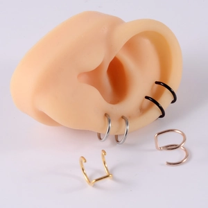 Close-up of double-layered stainless steel ear cuffs in black and silver on ear model