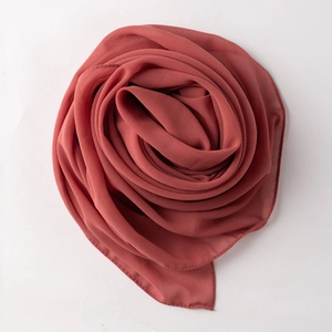 Detailed texture of rose-folded dark brick red chiffon scarf with soft drape finish