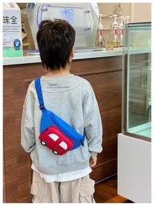 Close-up of a child wearing a blue and red car-shaped waist bag with adjustable straps