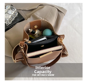 Interior view showing the large capacity and storage compartments of the brown bucket bag