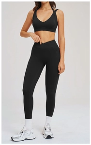 Dettaglio del set yoga nero con reggiseno sportivo incrociato e leggings a vita alta