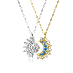 Close-up of gold moon and silver sun pendants with blue and white zircon inlay