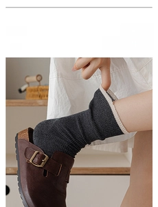 Detail of ribbed dark grey crew socks with cream trim and retro mule shoes