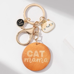 Détail d'un porte-clés chat avec médaillon en bois gravé CAT MAMA et chaton en émail