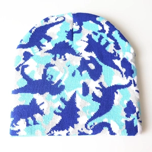 Detailansicht des blauen Dinosaurier-Jacquard-Strickmusters auf der Wintermütze.