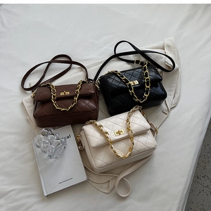 Three quilted crossbody bags in black, white, and brown with gold chain straps and metal locks