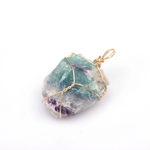 Detailed close-up of handmade gold wire-wrapped natural green and purple fluorite pendant