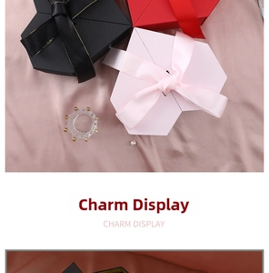 Macro view of heart-shaped gift boxes with silk ribbon and textured finish on pink satin