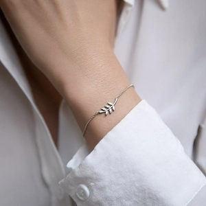 Detail of 925 sterling silver leaf bracelet with delicate chain on a woman wrist