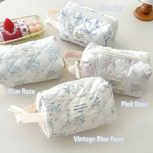 Set of quilted cotton makeup bags with floral and cat prints in a lifestyle setting