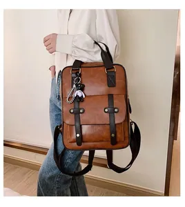 Detail of vintage brown backpack with black contrast straps and a cute bear charm