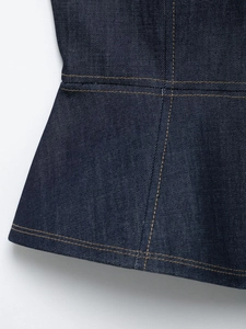 Detailed view of dark blue denim hem with contrasting yellow topstitching and twill texture