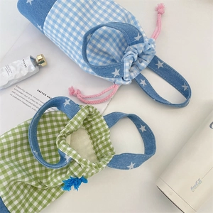 Detail of plaid water bottle bags with drawstring closure and star denim handles