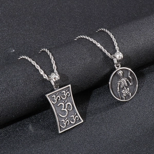 Vintage Silber Om-Symbol und Totenkopf Anhänger mit Kordelkette auf dunklem Hintergrund