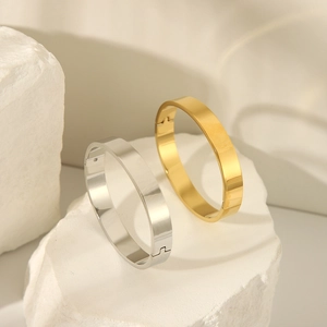 Detail view of gold and silver mirror polished stainless steel bangles with side hinge clasp