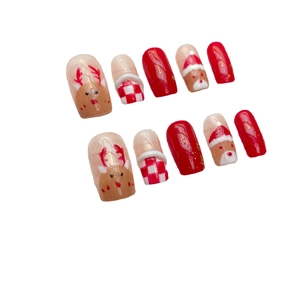 Handmade Christmas press-on nails featuring cute reindeer and Santa Claus art on red tips