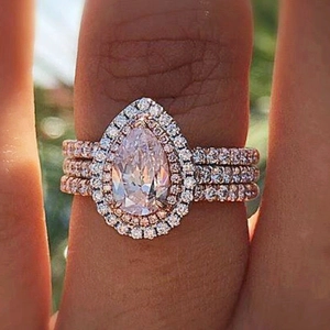 Three-layer pear cut crystal ring set in rose gold finish worn on finger outdoors