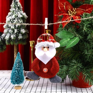 Detail of Santa Claus fabric ornament with snowflake button and hanging clip on Christmas tree