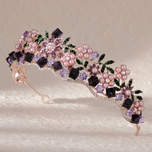 Detail of rose gold bridal tiara with pink pearl flowers and purple crystals