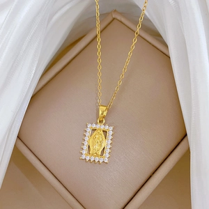 Detail of gold square Virgin Mary pendant with sparkling crystal halo on beige silk fabric