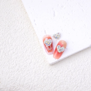 Detailed view of alloy heart-shaped rhinestones on gradient pink ombre press-on nails