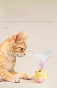 Dettaglio di un giocattolo per gatti a pulcino con piume e un gatto rosso curioso