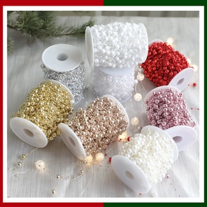 Macro detail of colorful artificial pearl bead chains on spools for Christmas decoration