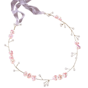 Detail of bridal headband with pink petals, white pearls, and adjustable purple ribbon