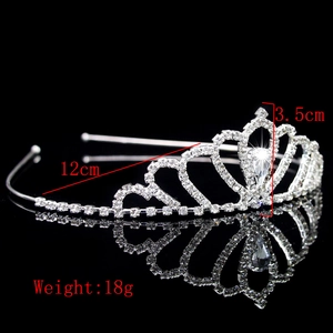 Close-up of silver bridal tiara featuring heart-shaped patterns and drop rhinestone