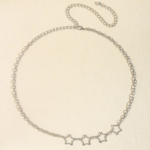 Detailed view of silver star link chain belt with lobster clasp on beige texture