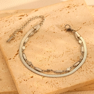 Détail du bracelet double couche en argent avec perles texturées sur pierre beige