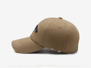 Dettaglio cappello baseball kaki vintage con ricamo blu e bordi effetto consumato