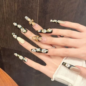 Macro shot of luxury gold floral press-on nails with 3D bows and cat-eye finish