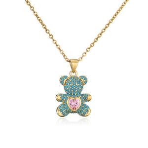 Close-up of golden bear pendant with turquoise zircon pavé and pink heart stone