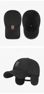 Detail view of winter baseball cap with earflaps, thick grey wool fabric and leather logo