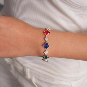 Détail du bracelet en argent avec trèfles en cristal rouge bleu et vert sur le poignet