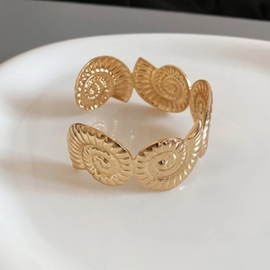 Macro detail of golden starfish nautilus texture on adjustable metal cuff bracelet