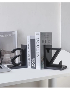 Modern black metal letter A and Z bookends shown in a minimalist office setting